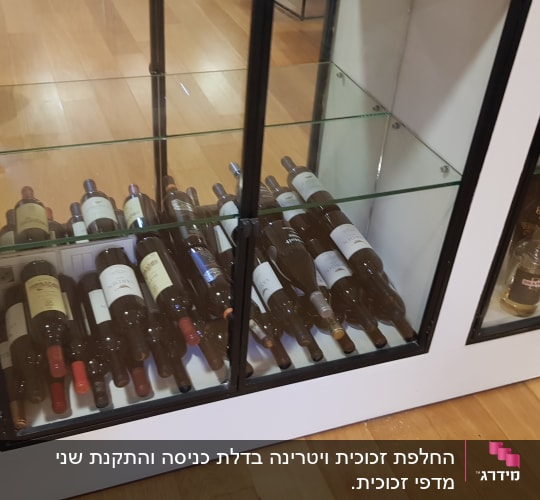 בקבוקי יין מאחורי דלתות זכוכית בארון תצוגה